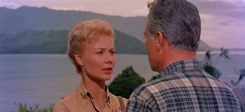 Movie still from “South Pacific” (1958), directed by Joshua Logan – An older man and a younger woman standing next to each other in front of a body of water; Close Up shot, Over the shoulder angle