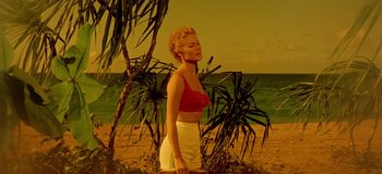 Movie still from “South Pacific” (1958), directed by Joshua Logan – A woman standing on a beach near a tree; Wide shot, Low angle