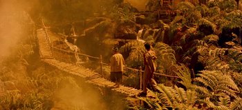 Movie still from “South Pacific” (1958), directed by Joshua Logan – Two men are walking across a bridge over a waterfall; Extreme Wide shot, High angle