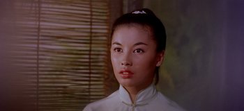 A woman in a white shirt is looking to her left