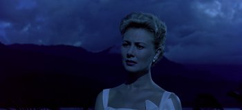 Movie still from “South Pacific” (1958), directed by Joshua Logan – A woman in a white dress standing in front of a mountain range; Close Up shot, Low angle
