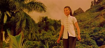 Movie still from “South Pacific” (1958), directed by Joshua Logan – A woman in a white shirt is standing in front of trees; Medium shot, Low angle
