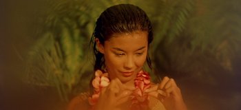 Movie still from “South Pacific” (1958), directed by Joshua Logan – A young woman wearing a flower lei in the rain; Close Up shot, High angle