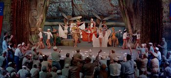 Movie still from “South Pacific” (1958), directed by Joshua Logan – A group of people are performing on a stage; Wide shot, High angle