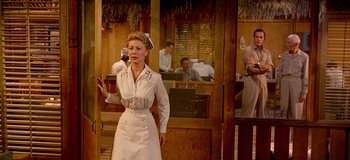 Movie still from “South Pacific” (1958), directed by Joshua Logan – A woman dressed as a nurse standing in front of people; Medium shot, Low angle