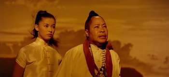 Movie still from “South Pacific” (1958), directed by Joshua Logan – A man and a woman standing next to each other in front of a painting; Medium shot, Low angle