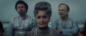 Movie still from “Southland Tales” (2006), directed by Richard Kelly – An older woman with a gray wig is posing for a picture; Medium shot, Low angle