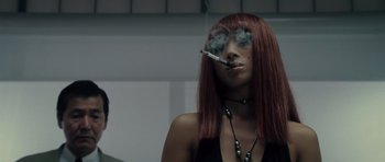 Movie still from “Southland Tales” (2006), directed by Richard Kelly – A woman with red hair smoking a cigarette in her mouth; Close Up shot, Low angle