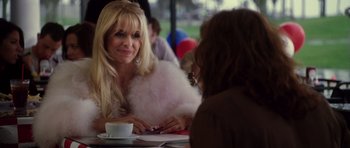 Movie still from “Southland Tales” (2006), directed by Richard Kelly – A woman sitting at a table in front of another woman; Close Up shot, Over the shoulder angle