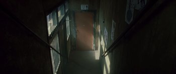 Movie still from “Southland Tales” (2006), directed by Richard Kelly – A door way leading to a room with a railing; Wide shot, High angle