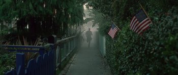 Movie still from “Southland Tales” (2006), directed by Richard Kelly – A man is running down a foggy street; Extreme Wide shot, High angle