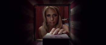 Movie still from “Southland Tales” (2006), directed by Richard Kelly – A beautiful blonde woman looking through a window; Close Up shot, High angle