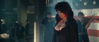 Movie still from “Southland Tales” (2006), directed by Richard Kelly – A woman in a black dress and red earrings; Medium shot, Over the shoulder angle