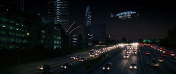 Cars are driving down a highway at night