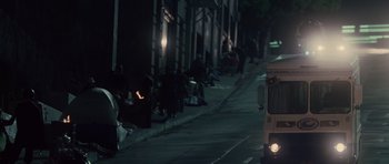 Movie still from “Southland Tales” (2006), directed by Richard Kelly – People sitting on the side of the street at night; Extreme Wide shot, High angle