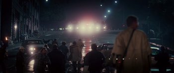 Movie still from “Southland Tales” (2006), directed by Richard Kelly – A group of people walking down a street at night; Extreme Wide shot, High angle