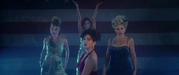 Movie still from “Southland Tales” (2006), directed by Richard Kelly – A group of women standing next to each other in dresses; Wide shot, Low angle