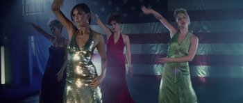 Movie still from “Southland Tales” (2006), directed by Richard Kelly – A group of women dancing in front of an american flag; Medium shot, Low angle