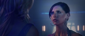 Movie still from “Southland Tales” (2006), directed by Richard Kelly – A woman is looking at another woman in a dark room; Close Up shot, Over the shoulder angle