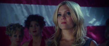 Movie still from “Southland Tales” (2006), directed by Richard Kelly – A woman with blonde hair and blue eyes looking at the camera with another woman in the background; Close Up shot, Low angle