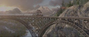 Movie still from “A Walk Among the Tombstones” (2014), directed by Scott Frank – A train traveling over a bridge near a mountain; Extreme Wide shot, High angle