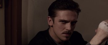 Movie still from “A Walk Among the Tombstones” (2014), directed by Scott Frank – A person wearing a suit and tie; Close Up shot, Over the shoulder angle