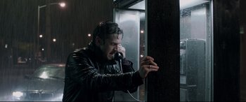 Movie still from “A Walk Among the Tombstones” (2014), directed by Scott Frank – A man talking on a phone next to an elevator; Close Up shot, Low angle