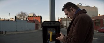 Movie still from “A Walk Among the Tombstones” (2014), directed by Scott Frank – A man standing in front of a parking meter; Close Up shot, Low angle