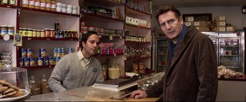 Movie still from “A Walk Among the Tombstones” (2014), directed by Scott Frank – Two men standing behind a counter in a store; Medium shot, Over the shoulder angle
