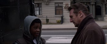 Movie still from “A Walk Among the Tombstones” (2014), directed by Scott Frank – A man talking to a young man on the side of the street; Close Up shot, Over the shoulder angle