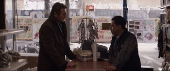 Movie still from “A Walk Among the Tombstones” (2014), directed by Scott Frank – Two men sitting at a table in front of each other; Medium shot, Over the shoulder angle