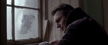 Movie still from “A Walk Among the Tombstones” (2014), directed by Scott Frank – A man sitting in front of an open window; Close Up shot, Low angle