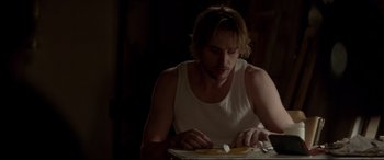 Movie still from “A Walk Among the Tombstones” (2014), directed by Scott Frank – A man sitting at a table with food in front of him; Medium shot, Over the shoulder angle