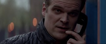 Movie still from “A Walk Among the Tombstones” (2014), directed by Scott Frank – A person wearing a black jacket; Close Up shot, Over the shoulder angle