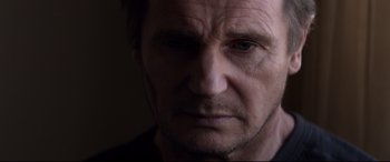 Movie still from “A Walk Among the Tombstones” (2014), directed by Scott Frank – A man's face in a dark room; Close Up shot, Low angle