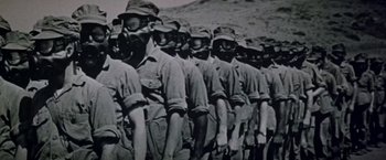 Movie still from “Soylent Green” (1973), directed by Richard Fleischer – A group of men standing next to each other wearing gas masks; Close Up shot, High angle