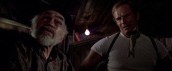 Movie still from “Soylent Green” (1973), directed by Richard Fleischer – Two men standing next to each other in front of a book shelf; Medium shot, Low angle