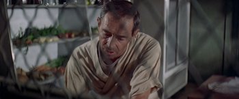 Movie still from “Soylent Green” (1973), directed by Richard Fleischer – An older man in tan shirt looking down at a table; Close Up shot, High angle