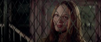 Movie still from “Soylent Green” (1973), directed by Richard Fleischer – A woman looking through a chain link fence at night; Close Up shot, Over the shoulder angle