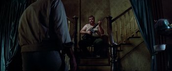 Movie still from “Soylent Green” (1973), directed by Richard Fleischer – A man sitting on the stairs holding a guitar; Medium shot, Low angle