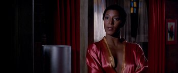 Movie still from “Soylent Green” (1973), directed by Richard Fleischer – A woman in a red and yellow robe looking out a window; Close Up shot, Over the shoulder angle