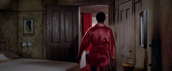 Movie still from “Soylent Green” (1973), directed by Richard Fleischer – A woman in a red robe walking into a bedroom; Medium shot, Over the shoulder angle