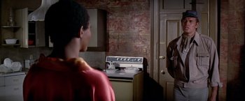 Movie still from “Soylent Green” (1973), directed by Richard Fleischer – A man standing in front of an oven in a kitchen; Medium shot, Over the shoulder angle