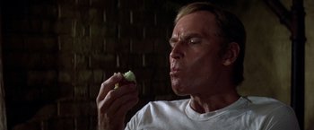 Movie still from “Soylent Green” (1973), directed by Richard Fleischer – A person eating a piece of food; Close Up shot, Overhead angle