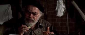 Movie still from “Soylent Green” (1973), directed by Richard Fleischer – An older man eating a sandwich in a room; Close Up shot, High angle