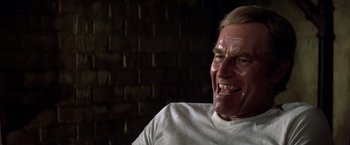 Movie still from “Soylent Green” (1973), directed by Richard Fleischer – An older man with a white shirt is smiling; Close Up shot, High angle