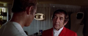 Movie still from “Soylent Green” (1973), directed by Richard Fleischer – A man in a red jacket talking to another man in a white shirt; Close Up shot, Over the shoulder angle