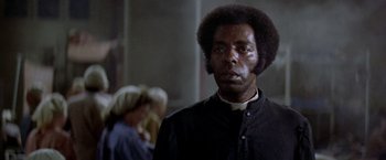 Movie still from “Soylent Green” (1973), directed by Richard Fleischer – A man in a black shirt and black jacket; Close Up shot, Low angle