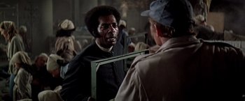 Movie still from “Soylent Green” (1973), directed by Richard Fleischer – A man talking to another man in front of a mirror; Medium shot, Over the shoulder angle