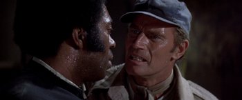 Movie still from “Soylent Green” (1973), directed by Richard Fleischer – A man and a black man face each other; Close Up shot, Over the shoulder angle